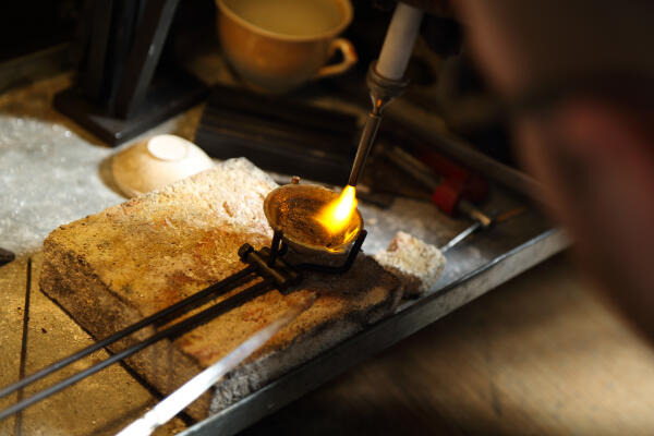 Goldschmied schmilzt Edelmetall Goldschmied schmilzt Edelmetall