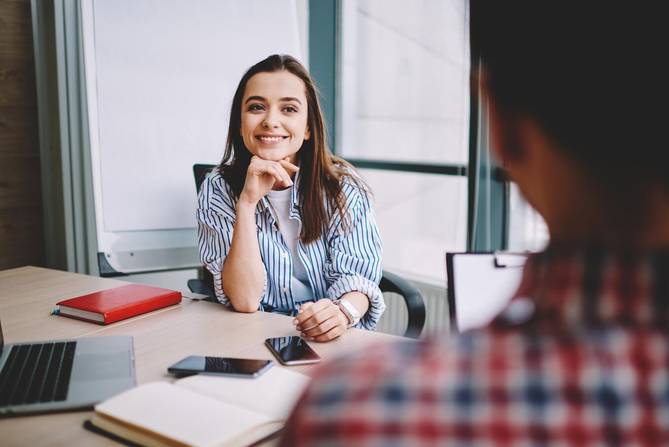 Logout Lehrstellenportal – Junge Frau sitzt lächelnd am Schreibtisch